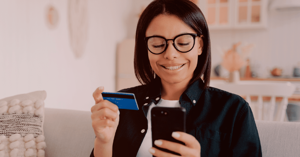 mulher utilizando celular e cartão de crédito